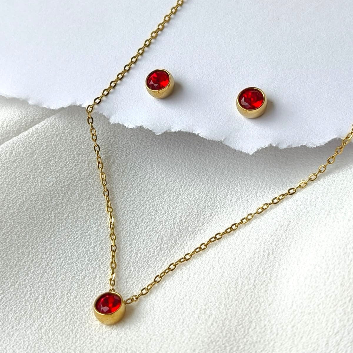 Conjunto em Aço Dourado com Pedras Vermelhas e Estilo Minimalista